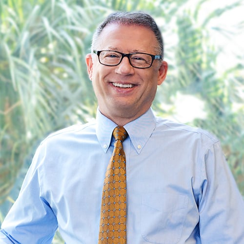 Man in blue dress shirt wearing black framed eyeglasses